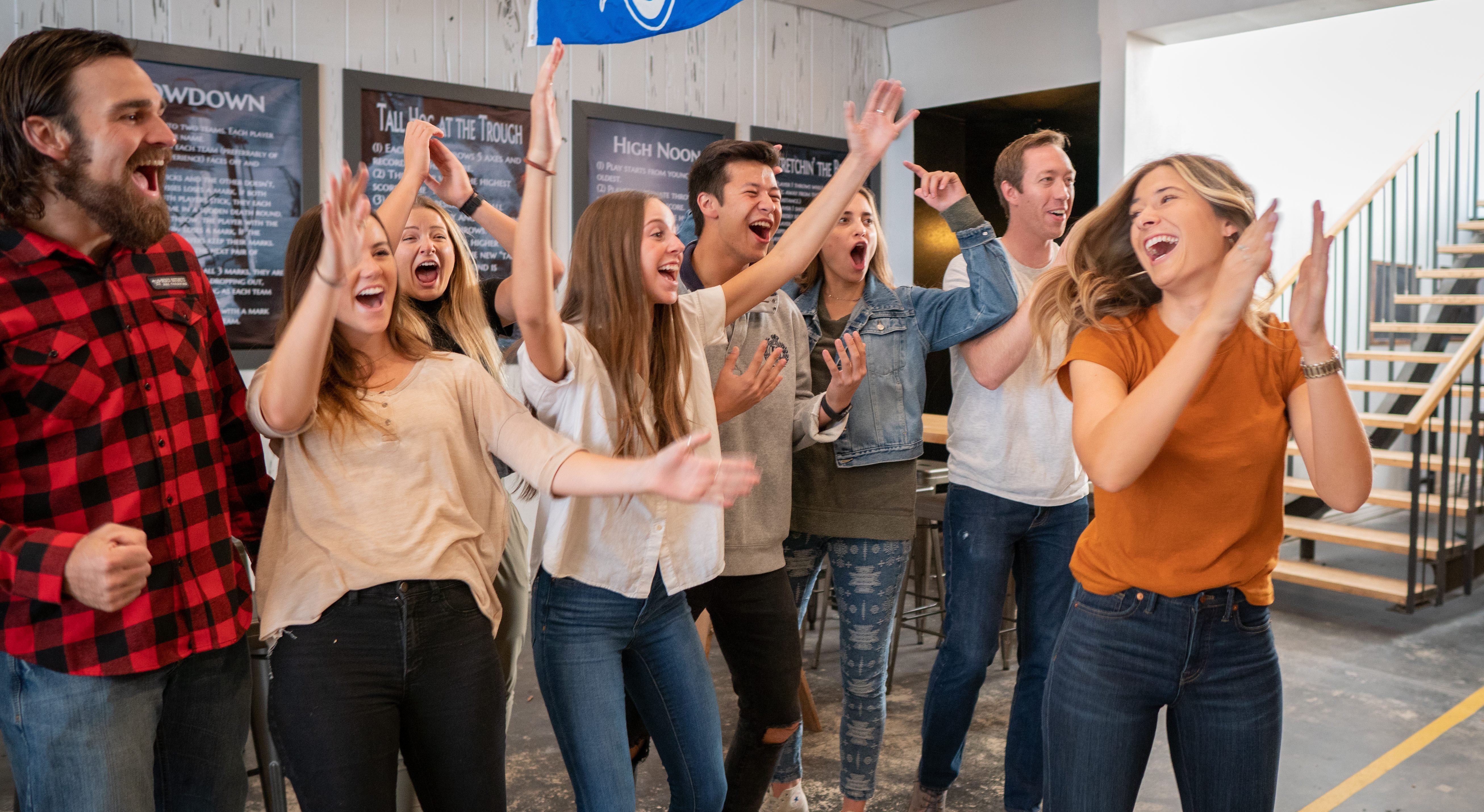 a group of friends celebrating an axe throwing score at Heber Hatchets