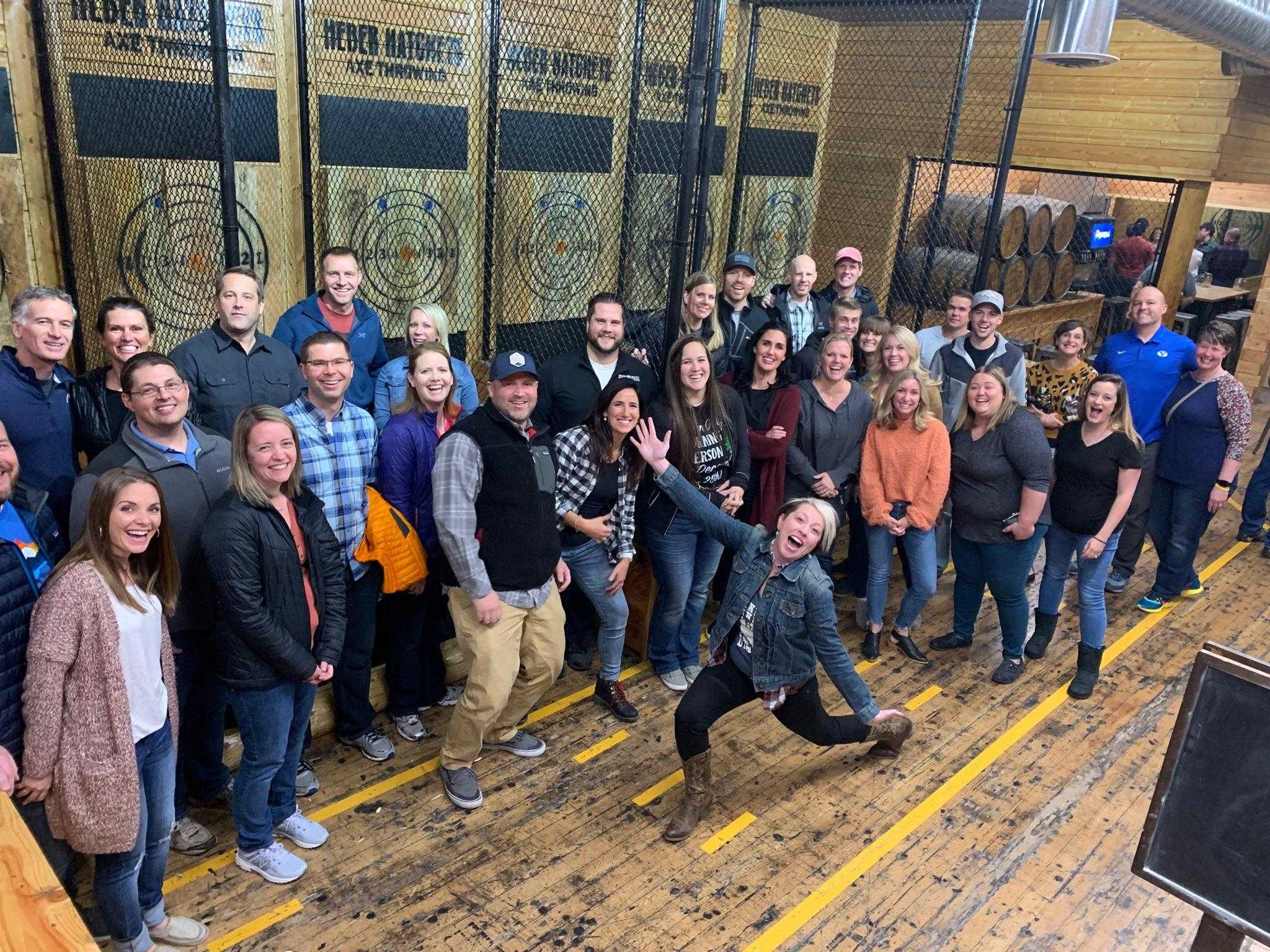 a group of men pose with axes during a bachelor party