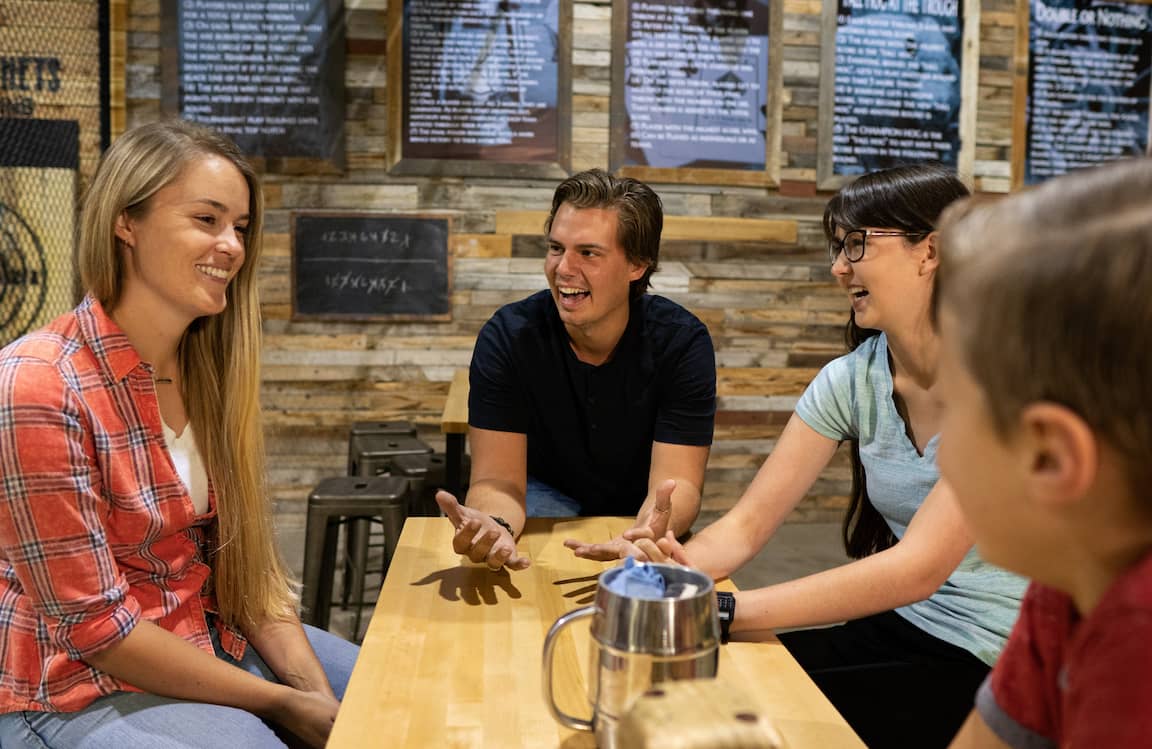 A group of people laughing together at a Heber Hatchets location